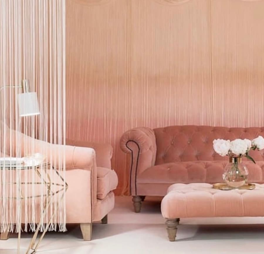 Seating area using varying tones of peach, from peach walls to peach furniture