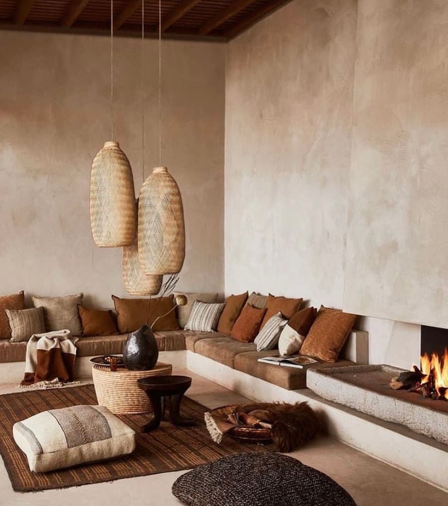 living room in various shades of brown, a corner sofa with lots of brown cushions by the side of a modern open fire