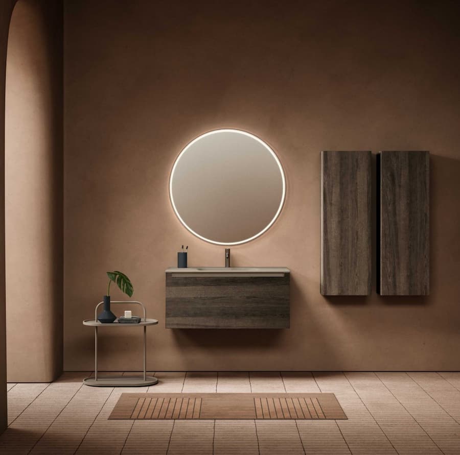 Brown inspired bathroom with large circular mirror with a light rim in the centre of the wall