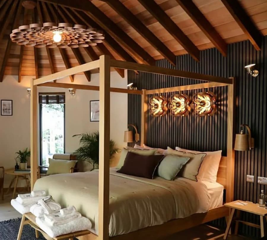 treehouse bedroom design with wooden roof and wall panelled wall, a four-poster bedroom and statement lighting