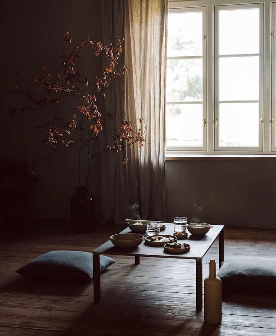 atmospheric living space with coffee table and cushions positioned on wooden floorboards