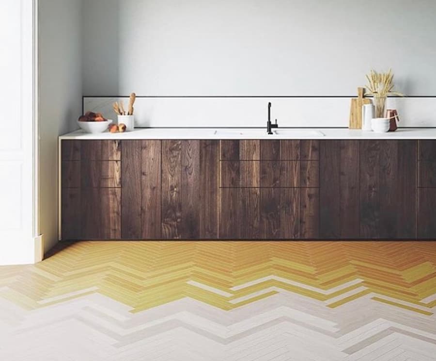 Dark brown kitchen with herringbone floor tiles made up of white and yellow