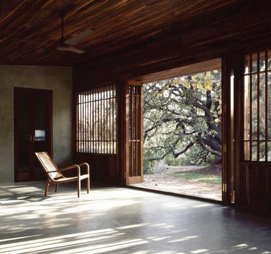 large space with wooden ceiling and a single reclining chair looking out of double doors