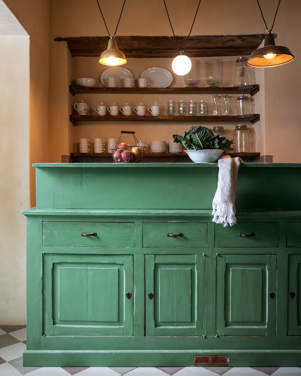 Vintage style green dresser positioned as part of the kitchen
