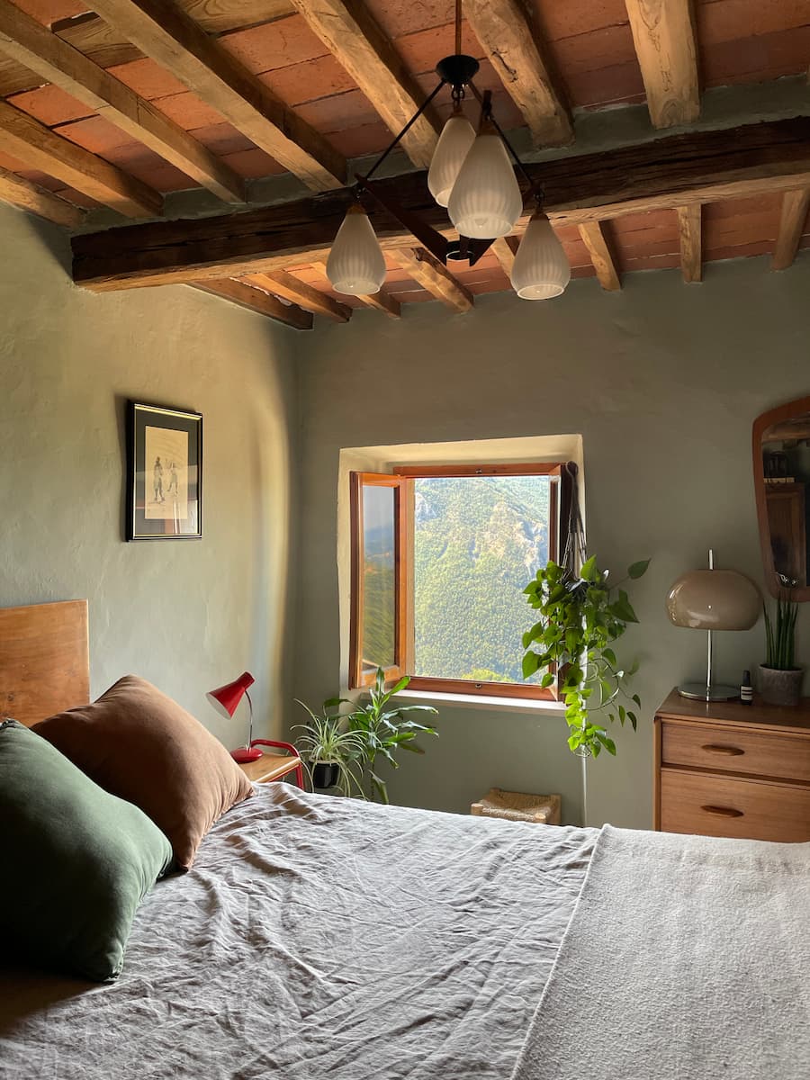 Bedroom with exposed beams and stunning views looking out to the mountain